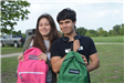 Two Teens Holding Backpacks