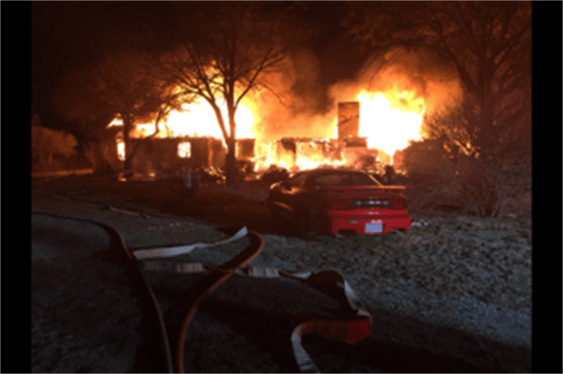 House Fire with a Red Car Parked in Front