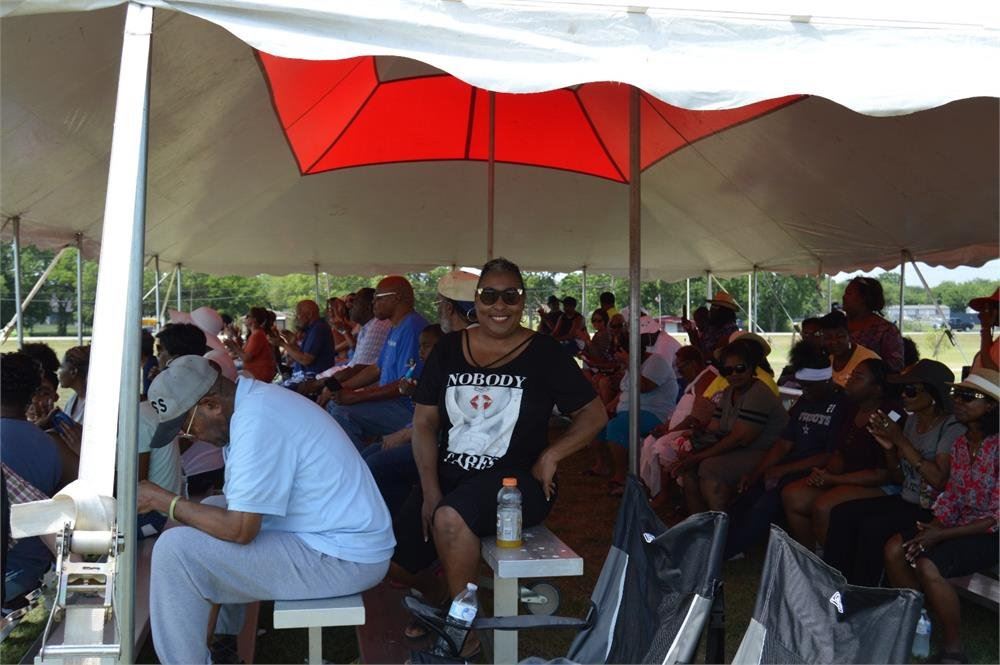 People Sitting in Bleachers Under a Tent