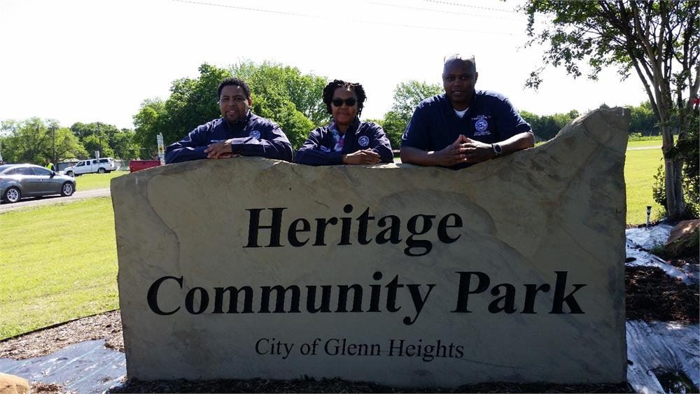 Volunteers by the Heritage Community Park Sign