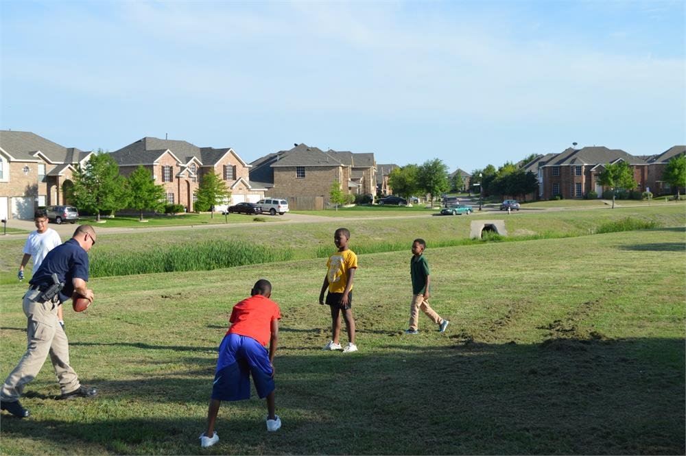 Police Officer Playing Football with Kids