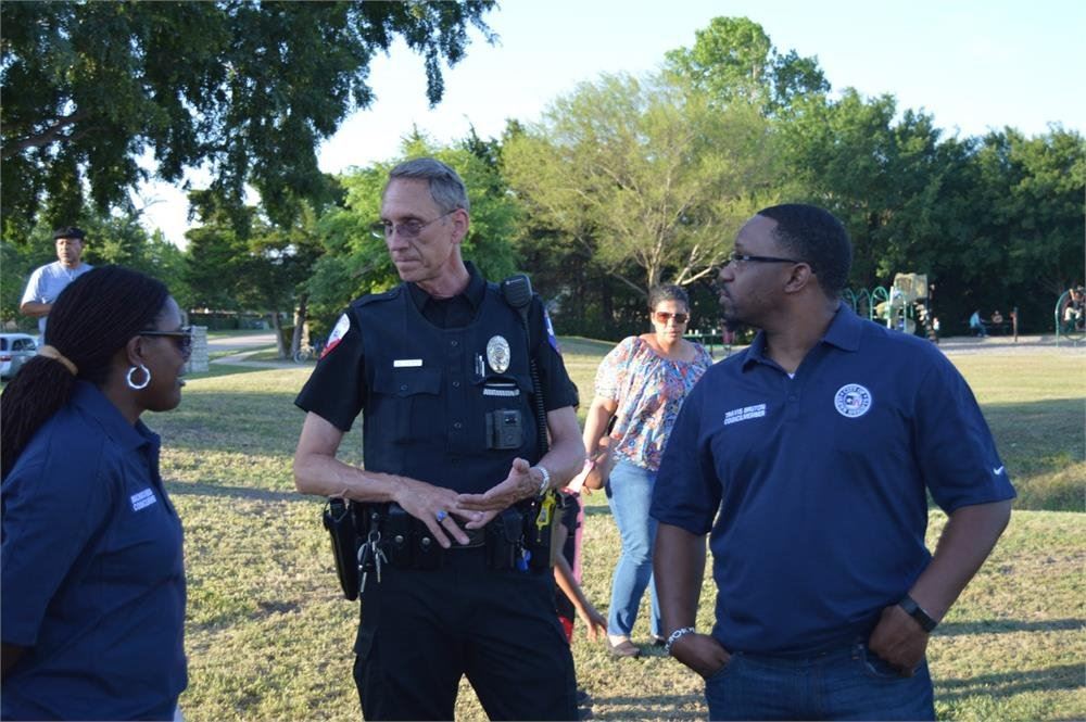 Police Officer Talking to City Employees