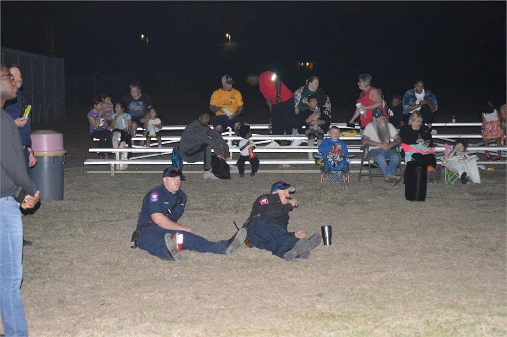 Firefighters and Families Watching a Movie in the Park